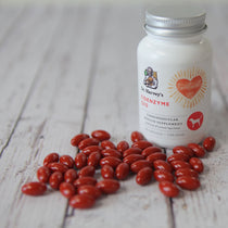 Dr. Harvey's Coenzyme Q10 supplement bottle with red capsules on a wooden surface