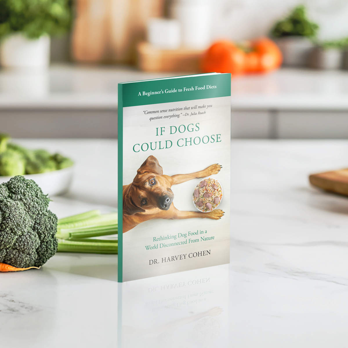 Book titled 'If Dogs Could Choose' by Dr. Harvey Cohen on a kitchen counter with vegetables.